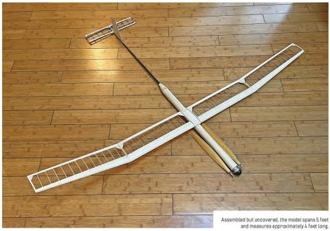 Large uncovered free-flight model glider assembled on a wood floor.