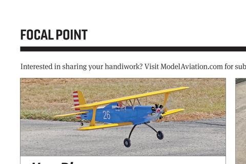 Yellow-and-blue biplane in flight over a paved surface