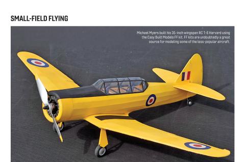 Yellow scale model T-6 Harvard on dark fabric background, three-quarter front view