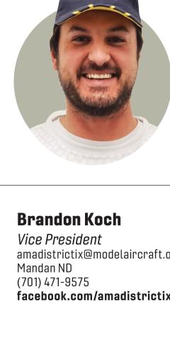 Headshot portrait of Brandon Koch wearing a baseball cap, smiling