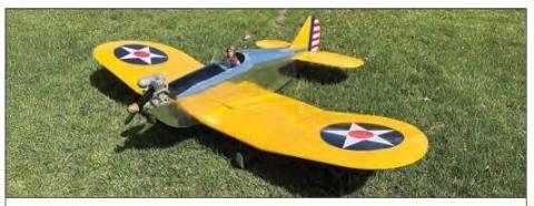 Yellow vintage-style model airplane on grass