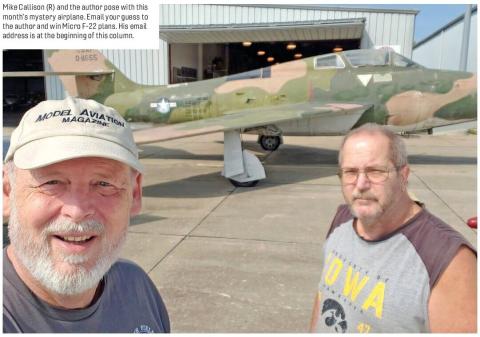 Dave Gee and Mike Callison posing in front of a camouflaged aircraft.
