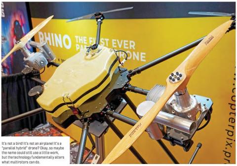 A large yellow parallel-hybrid multirotor drone with multiple wooden propellers and exposed engines on display.