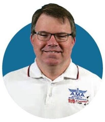 Portrait photograph of Jay Smith wearing glasses and a white AMA shirt