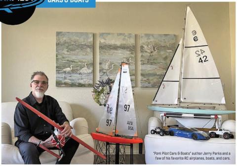 Jerry Parks seated beside model airplanes, a sailboat, and model cars.