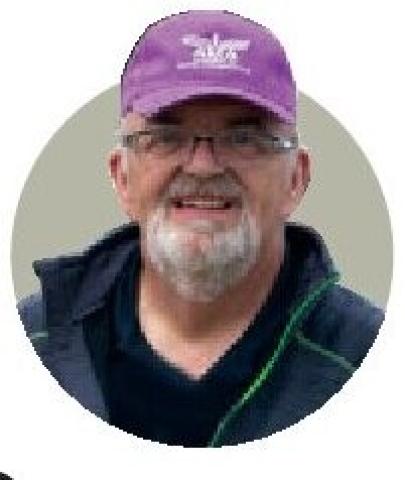 Portrait of Eric Williams wearing a purple cap.