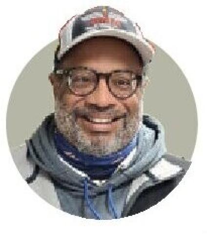 Circular portrait of Randy Gibson wearing a cap and scarf.