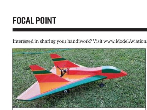 Red, orange, and green delta-wing model airplane on grass