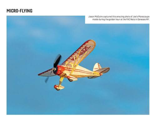 Monocoupe model flying against a blue sky