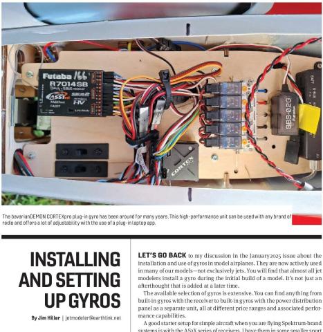 Close-up of a model aircraft gyro installation with receiver, servos, wiring, and battery