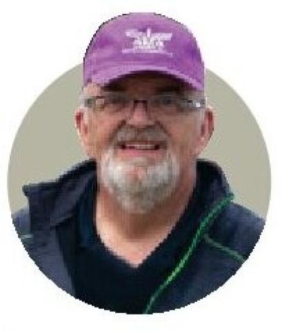 Portrait of Eric Williams wearing a purple cap.